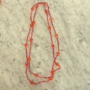Long continuous beaded necklace.